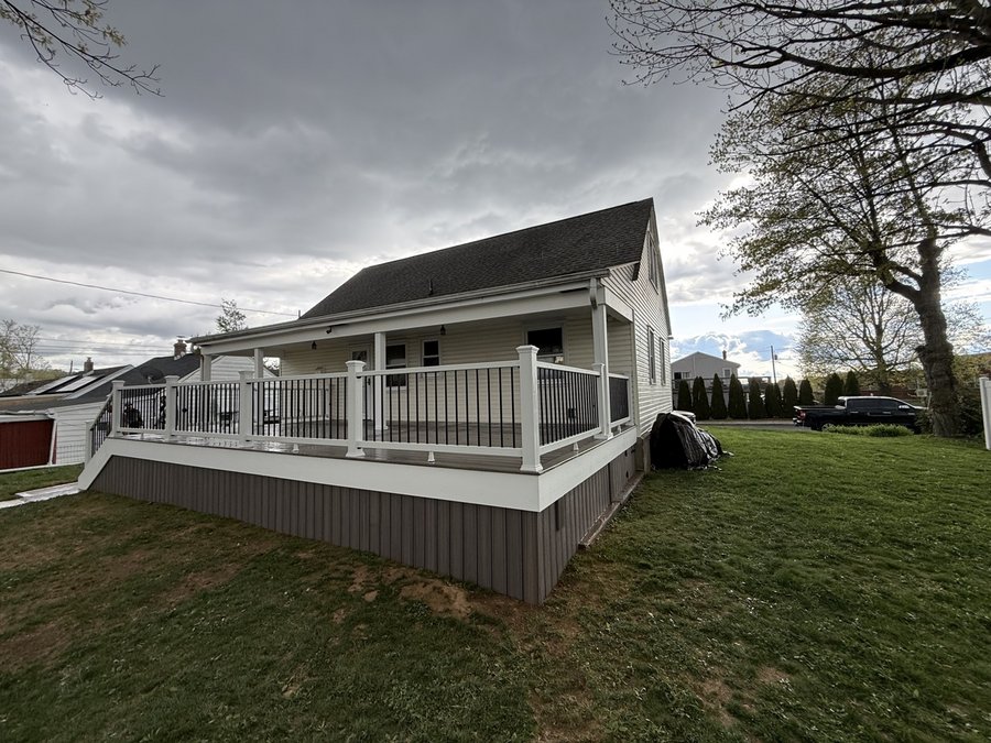 Large raised composite deck with finished skirting in a spacious backyard